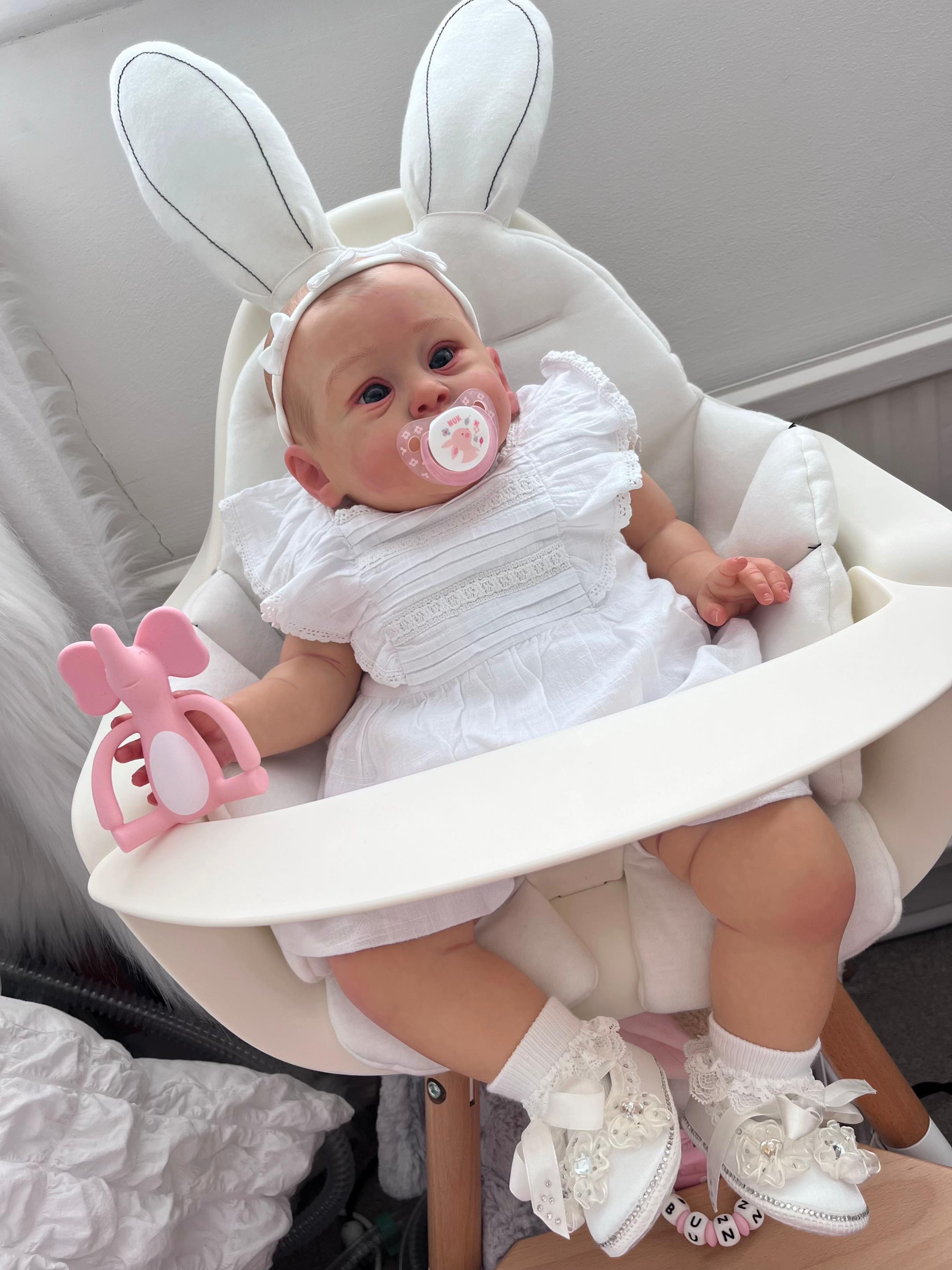 Baby Bella, a 24-inch realistic full body vinyl toddler reborn baby doll girl with hand-painted hair and open eyes by Reborn Heaven.